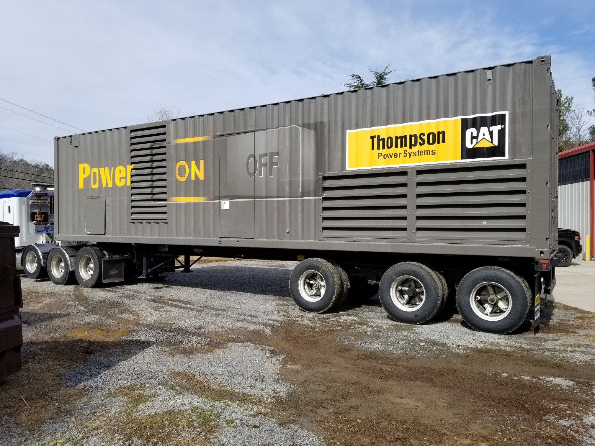Grey and yellow 52' trailer wrapped by sign source