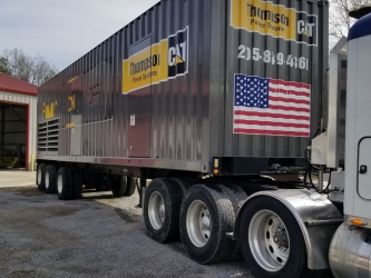 corner view of Grey and yellow 52' trailer wrapped by sign source