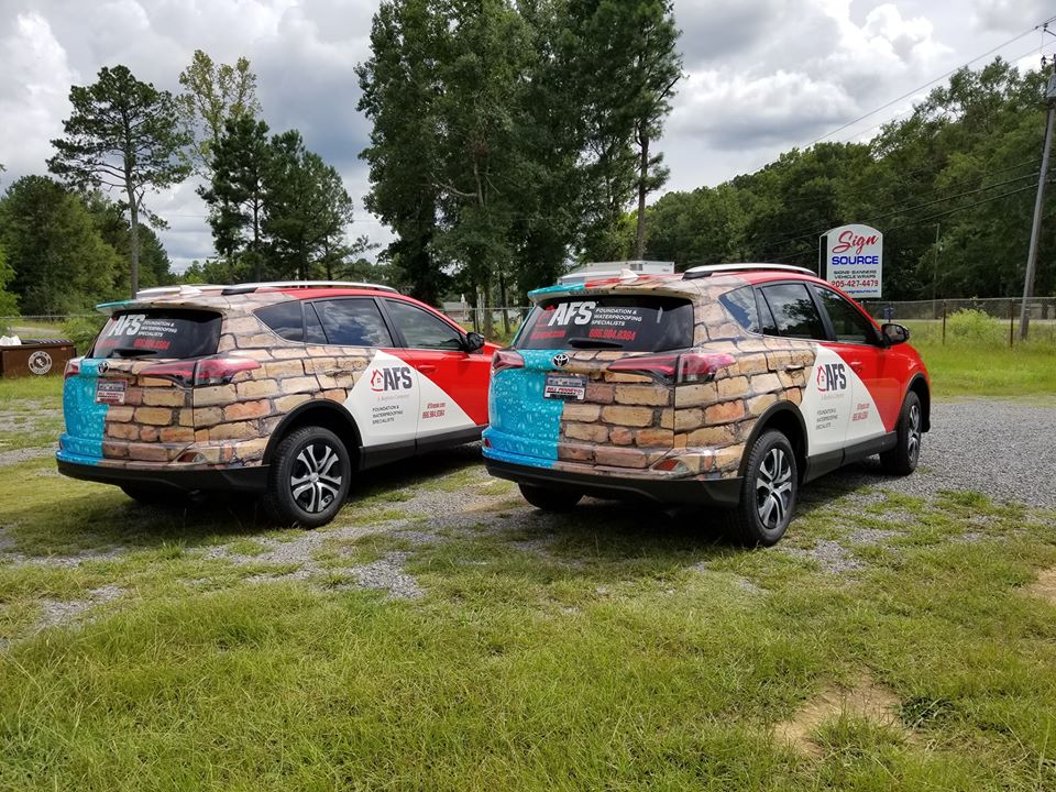 two parked blue afs vans wrapped in red white and blue pattern