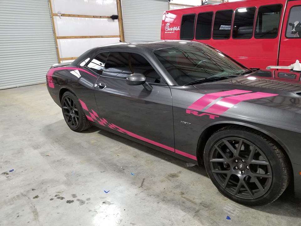 side of grey and pink dodge car wrapped with racing stripes