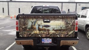Photo of a pickup truck's tailgate decorated with a scene of deer in a meadow
