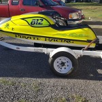 Yellow Personal watercraft on trailer. Side art is green flames and the words "Pirate Racing"