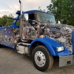 front of camo Wrapped tow truck parked in sign source lot