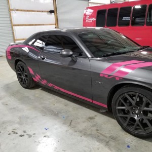 side of grey and pink dodge car wrapped with racing stripes