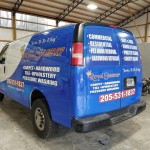 back of blue and white royal steamer advertisement on van wrap