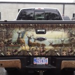 Photo of a pickup truck's tailgate decorated with a scene of deer in a meadow