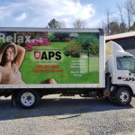 wrapped box truck with woman relaxing in a lawn showing lawn care and pest control advertisements